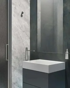 Industrial-style bathroom with metallic faucet, marble sink, and mirror.