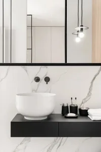 Minimalist bathroom with marble walls, black accents, and contemporary fixtures