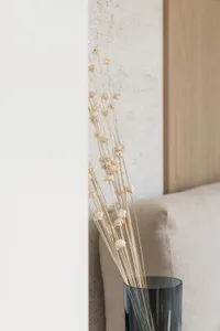 極簡室內設計中，玻璃花瓶插著乾燥白花。
