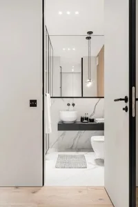 Modern black and marble bathroom with a floating vanity, sink, and toilet.