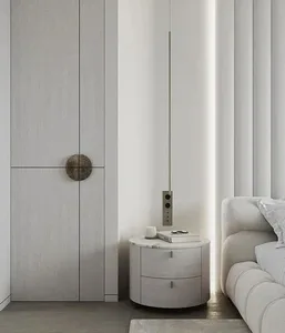 Modern minimalist bedroom featuring white materials, including a sleek round nightstand, a white sofa, and a large window wit
