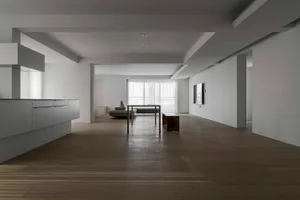 Contemporary minimalist living room with sleek, white furniture and wooden flooring.