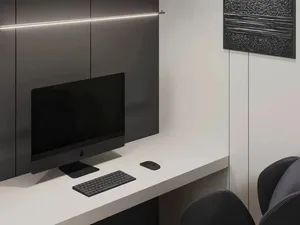 A minimalist office space featuring a white desk with a black iMac, a black keyboard, and a black mouse, with concrete walls