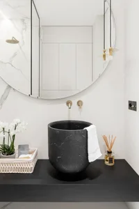 Black marble bathroom with modern design and white accents.