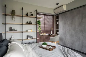 A minimalist bedroom featuring floating shelves, a cozy bed, and a desk area.
