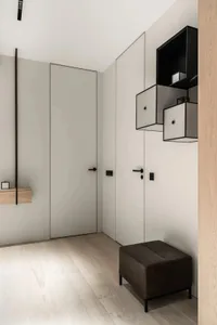 Modern minimalist room with white cabinets and wood flooring.