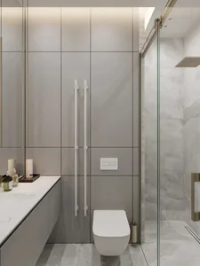 A modern bathroom featuring minimalist design with white tiles and glass shower enclosure.