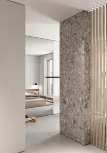 A modern bedroom with a terrazzo floor, minimalist design, and a large mirror on the wall.