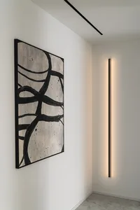 A modern interior design featuring concrete materials and linear lighting fixtures.