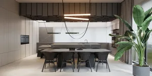 Modern kitchen with concrete countertops and floor, black chairs, and large green plant.