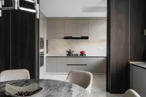 A modern kitchen with marble countertops and backsplash, featuring sleek design and clean lines.