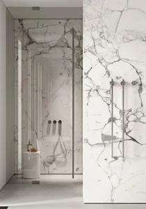A modern bathroom with marble walls and glass shower enclosure.