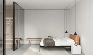 A modern minimalist bedroom with a white bed, brown headboard, and white bedding.