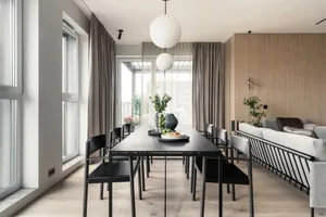 Contemporary living room featuring a minimalist aesthetic with a long, sleek table and comfortable seating arrangements.