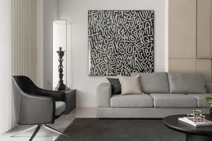 A living room with a grey sofa, black armchair, and mixed materials.