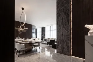 Modern living and dining room with marble floors and concrete accents.