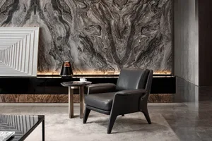 Modern living room with a grey leather armchair, marble side table, and a coffee table with a geometric frame. The wall featu