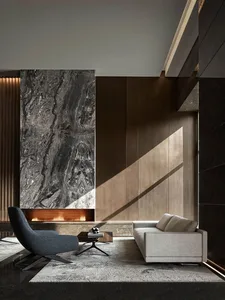 A modern living room with a marble fireplace, wooden furniture, and concrete walls.