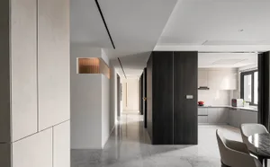 Modern residential kitchen featuring concrete walls and matte black wood