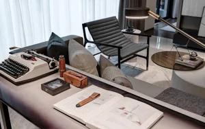 A modern living room with comfortable seating, a typewriter, and a coffee table.