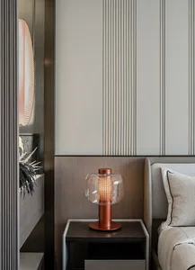A modern bedroom with a metallic glass nightstand.