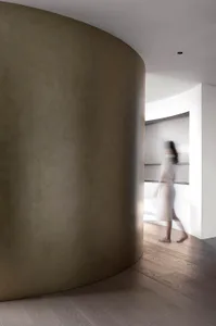 A minimalist interior with concrete walls and wooden flooring.