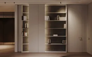 A minimalist living room with concrete interiors, featuring a bookshelf.
