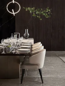 Modern dining room featuring a sleek dining table with white leather dining chairs, surrounded by a stylish marble counter an