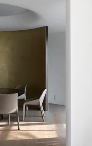 A modern dining room featuring wood flooring and minimalist furniture.