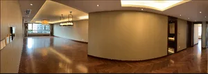 A spacious, modern living room featuring hardwood flooring.