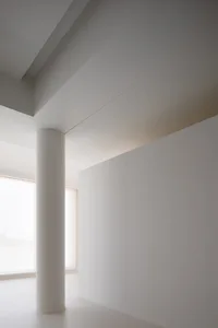 極簡室內空間，白色牆面搭配混凝土柱。
