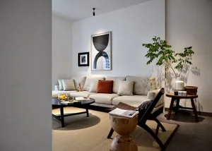 A minimalist living room with neutral-toned furniture and concrete elements.