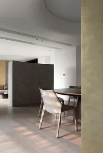 A modern living room with concrete walls, a wooden floor, and metal accents.