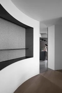 Modern minimalist kitchen with concrete walls, wooden flooring, and metallic accents