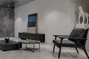 A modern interior with a minimalist design, showcasing black leather furniture on a marble floor.