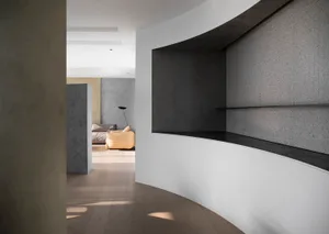 A modern residential interior with concrete walls and wooden flooring.