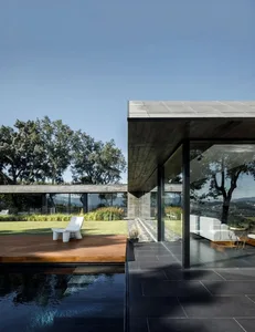 A modern residential exterior with glass and concrete features.