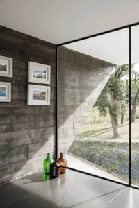 Interior design featuring minimalist concrete walls and windows with a view of nature.