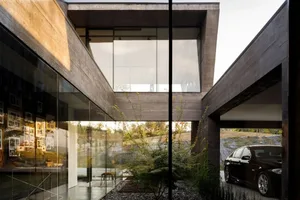 A modern house with concrete walls and a glass facade.