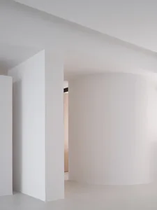 A minimalist white interior with curved walls and a clean, modern design.