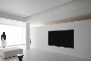 Minimalist living room with white walls, black television, and white furniture.