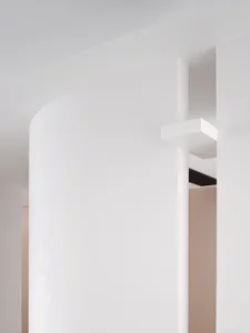 Minimalist office space featuring white-painted walls and concrete columns.