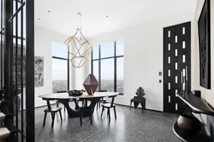 Modern dining room with a metal table and chairs, featuring large windows and a unique pendant light.
