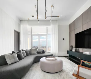 Modern living room featuring glass and wooden furniture and a large window with city skyline view.