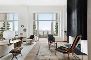 Modern living room featuring marble, leather, and glass materials.