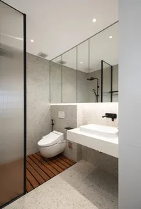 Modern minimalist bathroom with white fixtures, terrazzo floor, and large mirror.