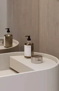 A sleek, modern bathroom counter featuring minimalist ceramic accessories and simple, elegant design details.
