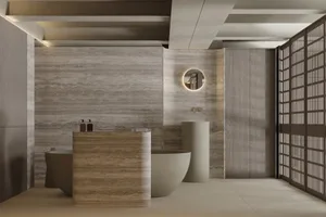 Modern bathroom with marble walls and floor, round pedestal sink, and freestanding bathtub.