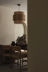 Dining room featuring wooden furniture, with a layered chandelier hanging over the table.