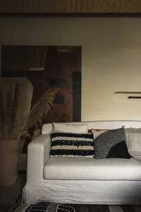 Modern living room featuring contemporary furniture, cushions, and an abstract painting.